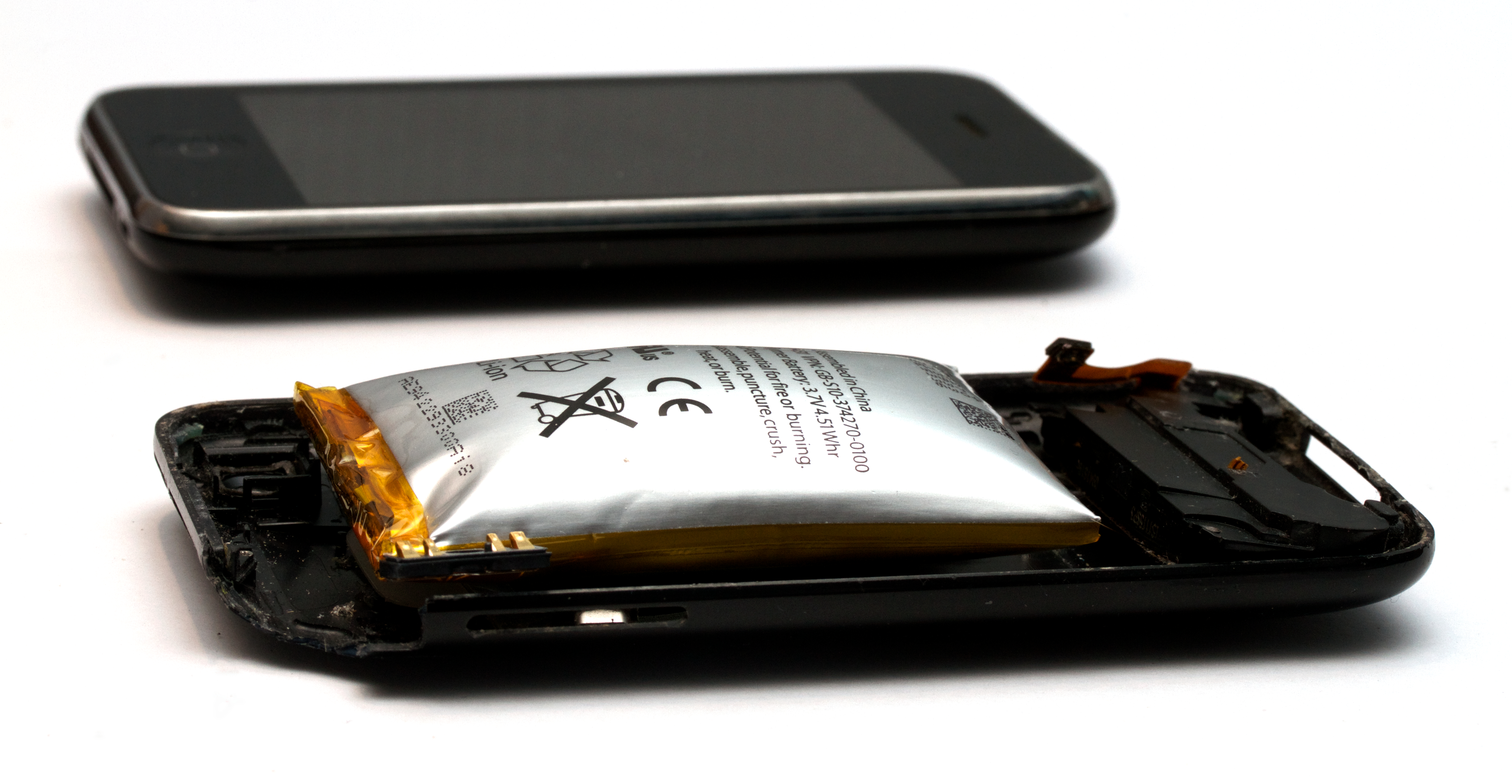 An expanded lithium-ion battery removed from a phone, showing how the pouch swells as the cell ages