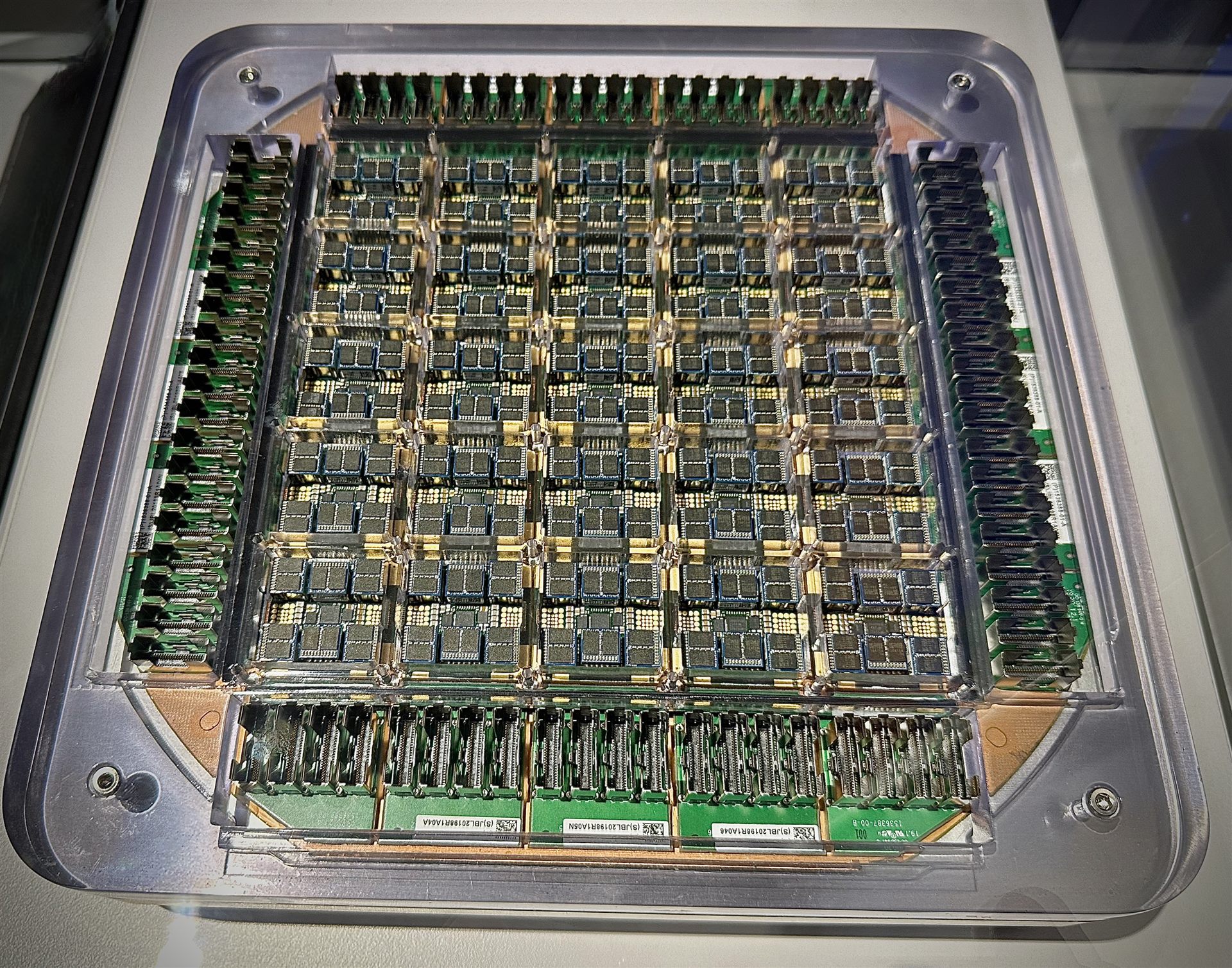A Tesla Dojo supercomputer training tile — a dense grid of custom AI accelerator chips